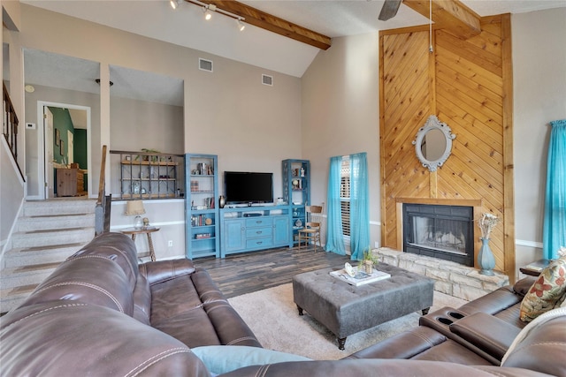 living room featuring a fireplace, wood-type flooring, beam ceiling, and high vaulted ceiling