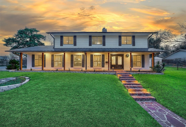 farmhouse inspired home featuring covered porch, a lawn, and french doors