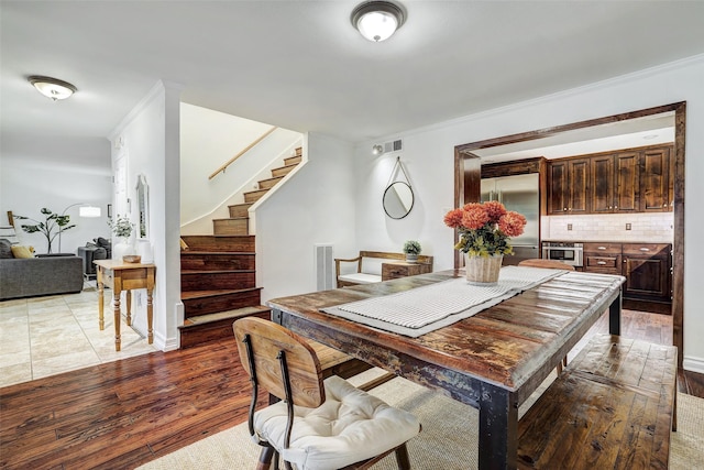 dining area featuring hardwood / wood-style floors and ornamental molding