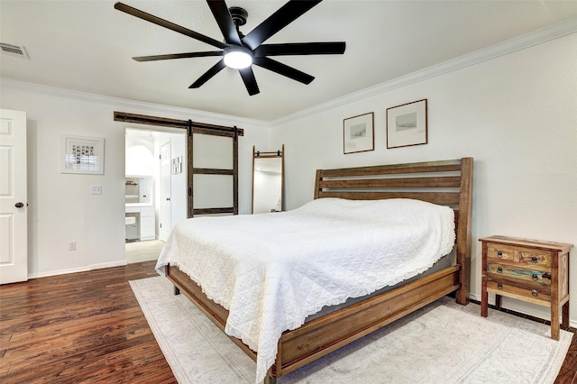 bedroom featuring ceiling fan, hardwood / wood-style flooring, a barn door, ornamental molding, and connected bathroom