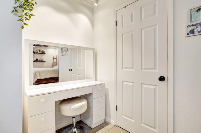 office space with built in desk, ornamental molding, and light tile patterned floors