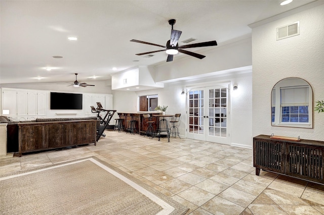 living room featuring ceiling fan, french doors, light tile patterned floors, ornamental molding, and lofted ceiling