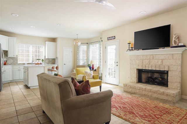 tiled living room with ceiling fan and sink