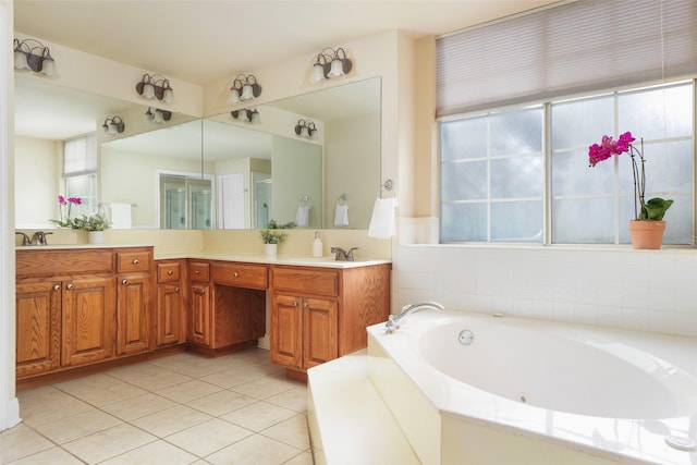 bathroom with a healthy amount of sunlight, tile patterned flooring, vanity, and a bathing tub