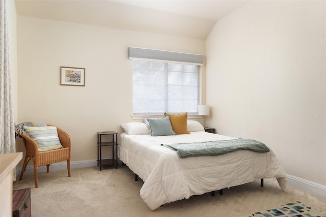 bedroom with lofted ceiling and light colored carpet