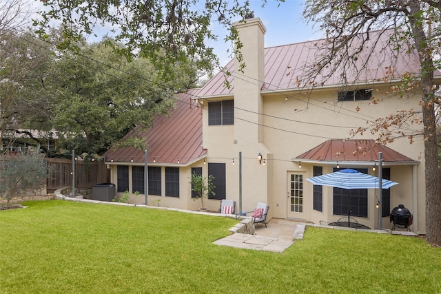 rear view of property with a yard and a patio area