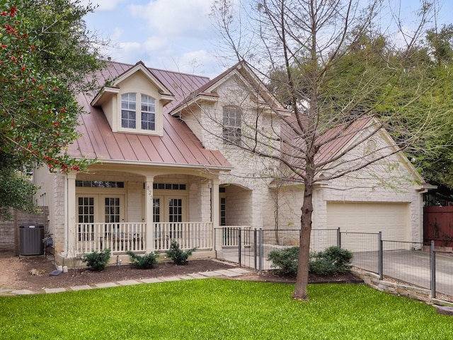 view of front of property featuring a porch, a garage, a front yard, and central air condition unit