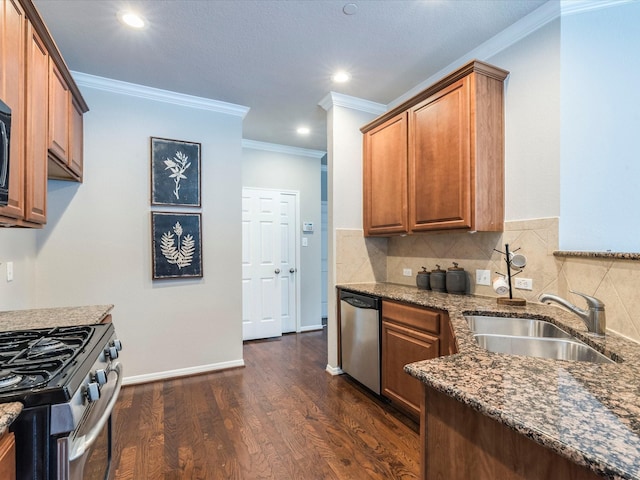 kitchen featuring appliances with stainless steel finishes, dark stone counters, sink, dark hardwood / wood-style floors, and crown molding