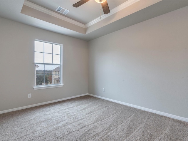 carpeted empty room with crown molding, ceiling fan, and a raised ceiling