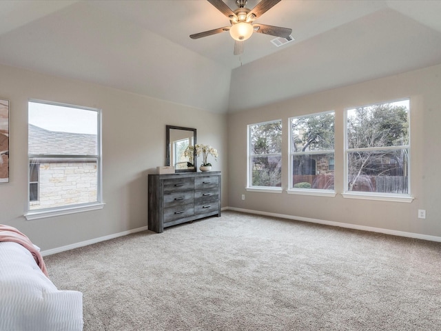 bedroom featuring ceiling fan, carpet flooring, vaulted ceiling, and a tray ceiling