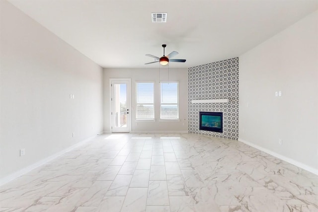 unfurnished living room with a tiled fireplace and ceiling fan