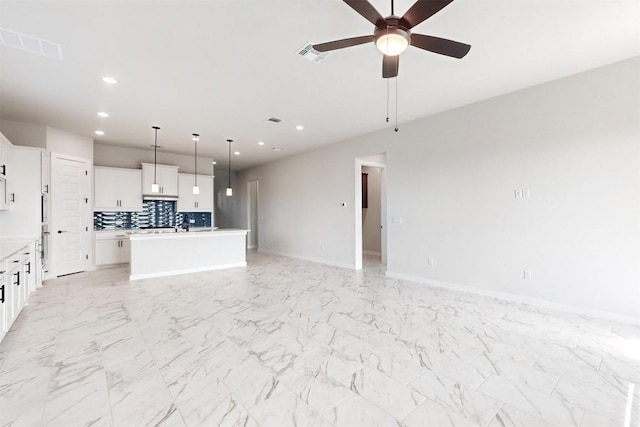 unfurnished living room with ceiling fan