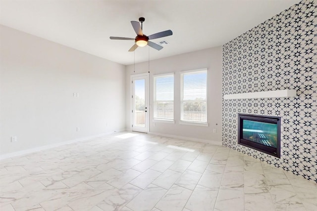 unfurnished living room featuring a tiled fireplace and ceiling fan