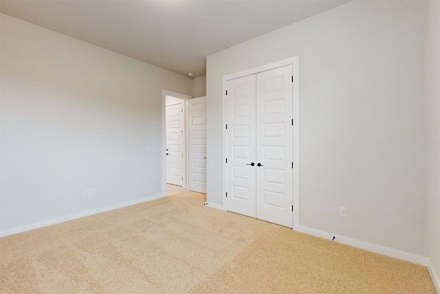 unfurnished bedroom featuring a closet and light carpet