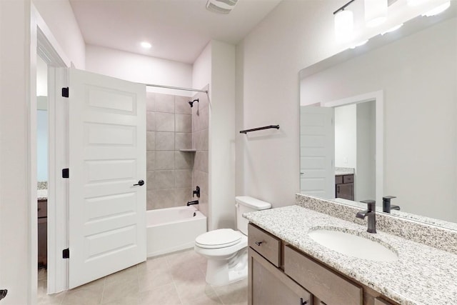 full bathroom with tile patterned flooring, vanity, tiled shower / bath combo, and toilet