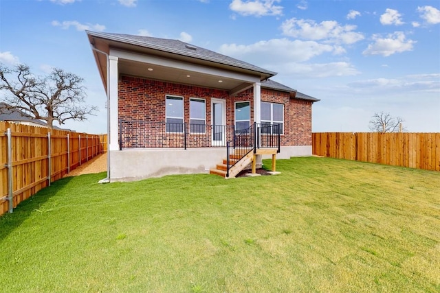 rear view of property featuring a lawn