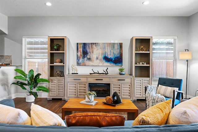 living room with dark wood-type flooring and a wealth of natural light