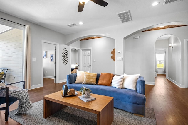 living room featuring a textured ceiling, ceiling fan, and dark hardwood / wood-style flooring