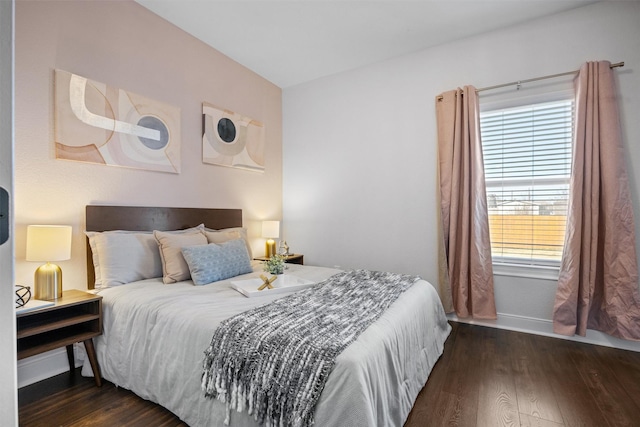 bedroom featuring multiple windows and dark hardwood / wood-style flooring