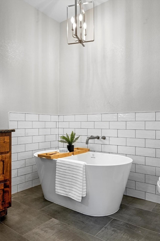 bathroom featuring a bath, tile patterned flooring, vanity, and tile walls