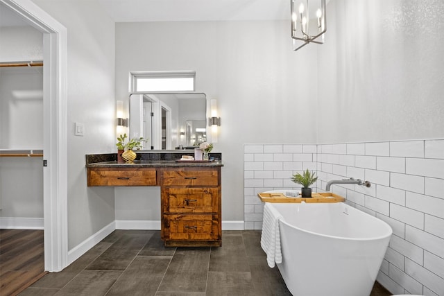 bathroom with a bath, tile walls, and vanity