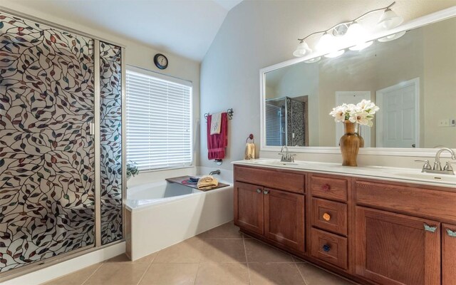 bathroom featuring vaulted ceiling, vanity, shower with separate bathtub, and tile patterned flooring