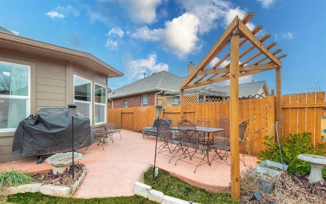 view of patio featuring fence, grilling area, a pergola, and outdoor dining space