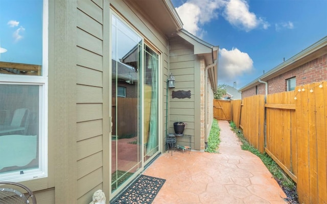 view of home's exterior with a patio area and fence