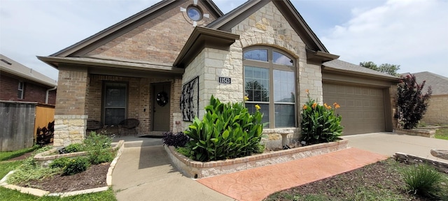 11513 Glen Knoll Dr, Manor, TX 78653 - view of front facade with an attached garage, stone siding, driveway, and a porch