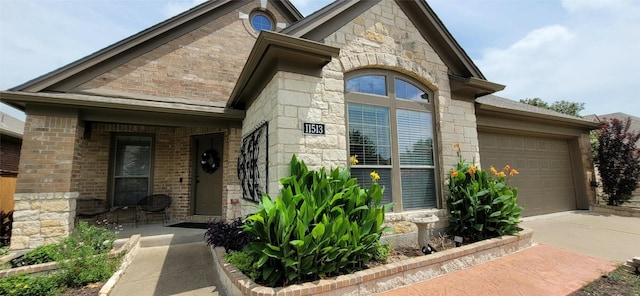 11513 Glen Knoll Dr, Manor, TX 78653 - doorway to property with stone siding, a garage, concrete driveway, and brick siding