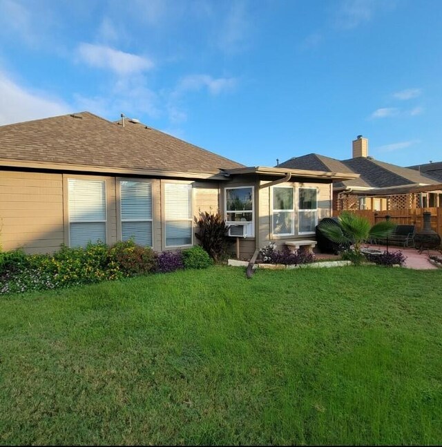 11513 Glen Knoll Dr, Manor, TX 78653 - rear view of property featuring a lawn, a chimney, a shingled roof, and a patio area