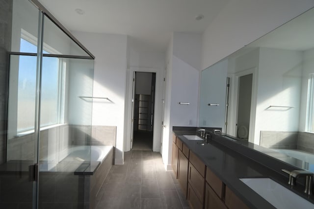 bathroom featuring independent shower and bath, a healthy amount of sunlight, wood-type flooring, and vanity