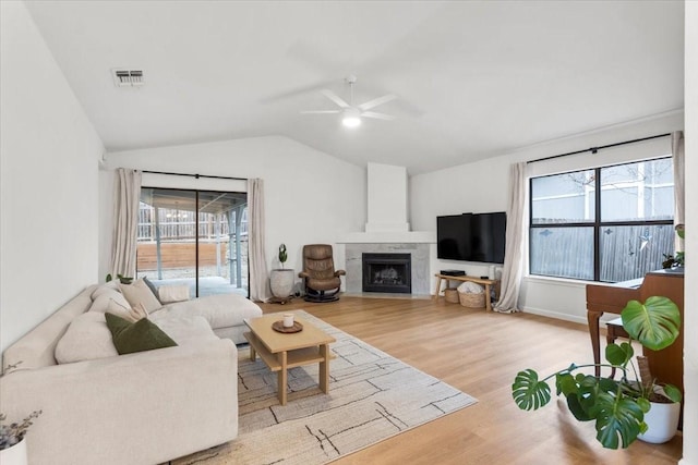 living room with light wood-type flooring, vaulted ceiling, and ceiling fan