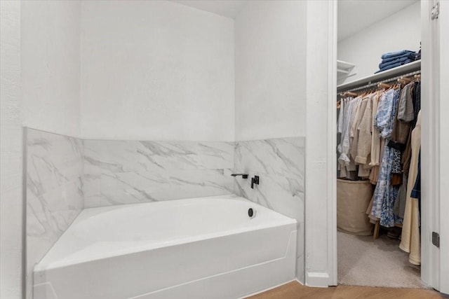 bathroom featuring hardwood / wood-style flooring and a bath