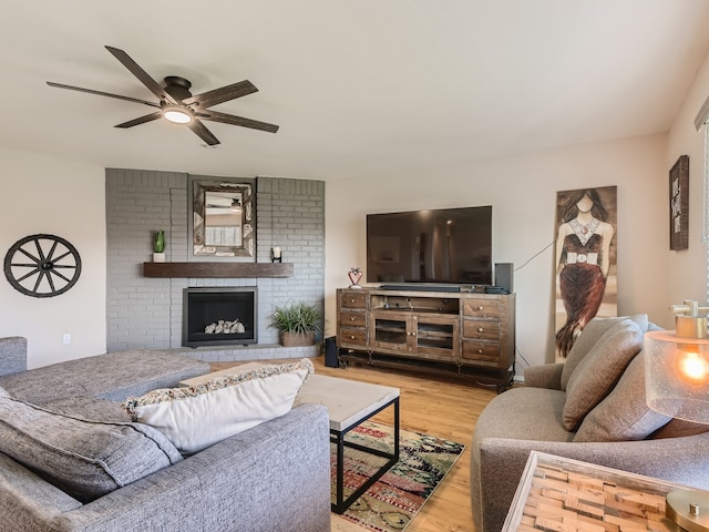 living room with ceiling fan, light hardwood / wood-style flooring, and a fireplace