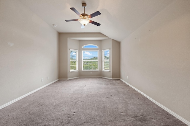 carpeted empty room with vaulted ceiling and ceiling fan