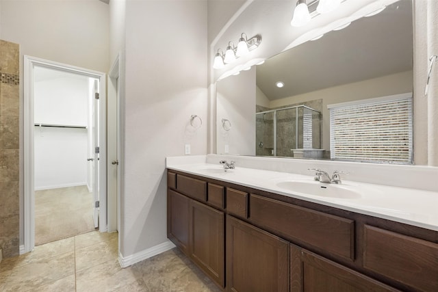 bathroom featuring vaulted ceiling, tile patterned flooring, a shower with shower door, and vanity