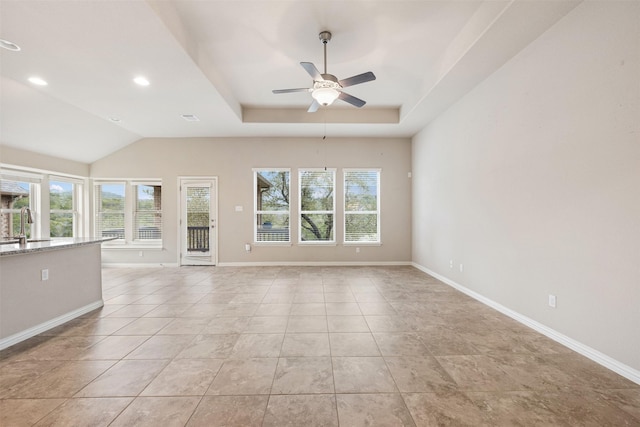 empty room featuring sink, ceiling fan, light tile patterned floors, and a tray ceiling