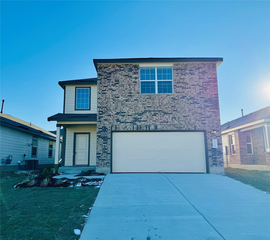 view of property featuring a garage and central AC unit