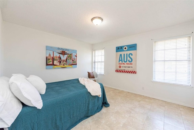 bedroom featuring baseboards and a textured ceiling