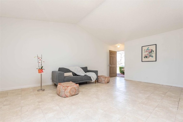 living area with baseboards and lofted ceiling