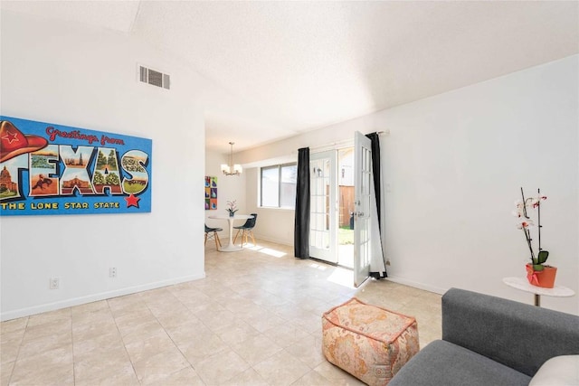 living area featuring visible vents, baseboards, lofted ceiling, and a chandelier