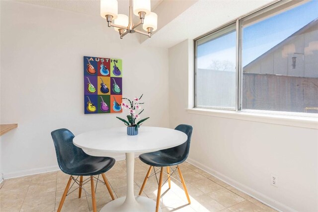 dining area with light tile patterned flooring, baseboards, and an inviting chandelier