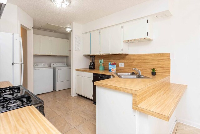 kitchen featuring dishwasher, light countertops, freestanding refrigerator, independent washer and dryer, and a sink