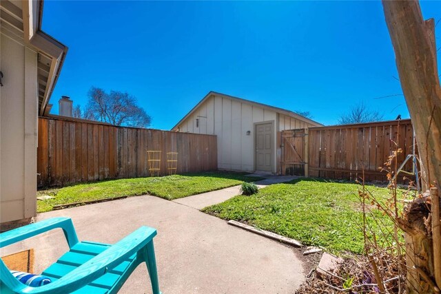 view of yard with a patio, a fenced backyard, and a gate