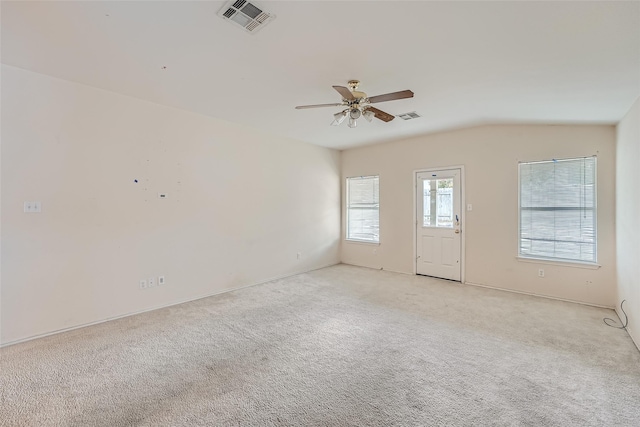 carpeted spare room with ceiling fan and vaulted ceiling