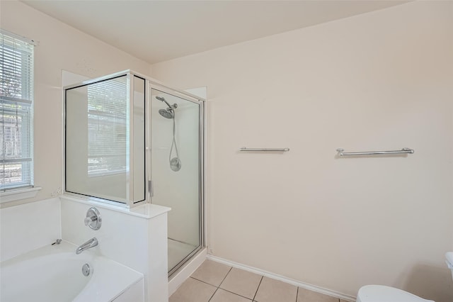 bathroom with a wealth of natural light, toilet, separate shower and tub, and tile patterned flooring