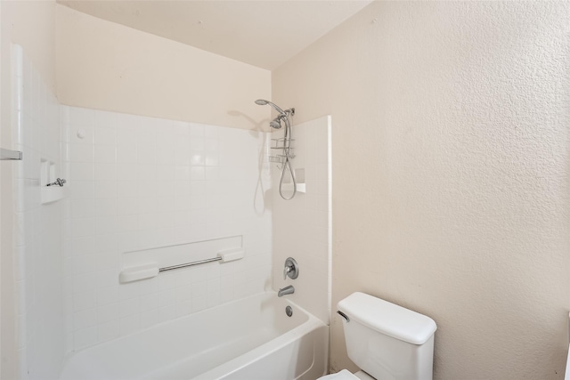 bathroom with toilet and tiled shower / bath