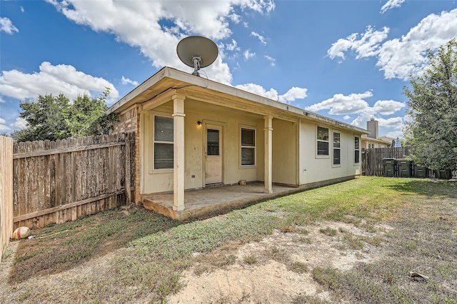 rear view of property featuring a patio area and a yard