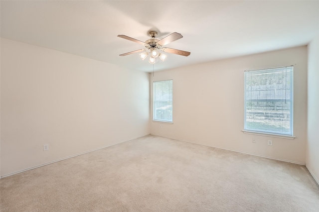 carpeted spare room with ceiling fan